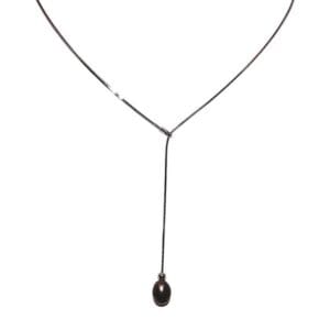 Minimalist necklace with a single black pendant.