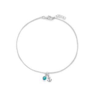 The Anchor with Turquoise Anklet is a silver chain adorned with an anchor charm and turquoise bead, featuring an adjustable clasp.