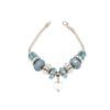 The Aqua Marine Crystal Bracelet is a silver piece adorned with blue and clear beads, featuring a heart charm at the center.