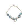 The Aqua Marine Crystal Bracelet is a silver piece with blue and clear beads, featuring a heart-shaped charm and a lobster clasp.