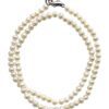 The Little Girl Pearl Necklace features white pearls arranged in a spiral and secured with a silver clasp.
