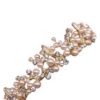 A decorative hair accessory in a floral design with champagne and gold pearls accented by opals.