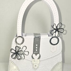 White handbag with silver floral decorations.