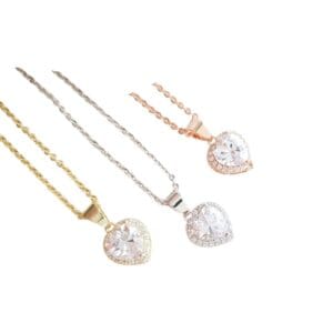 Three heart-shaped diamond necklaces on display.
