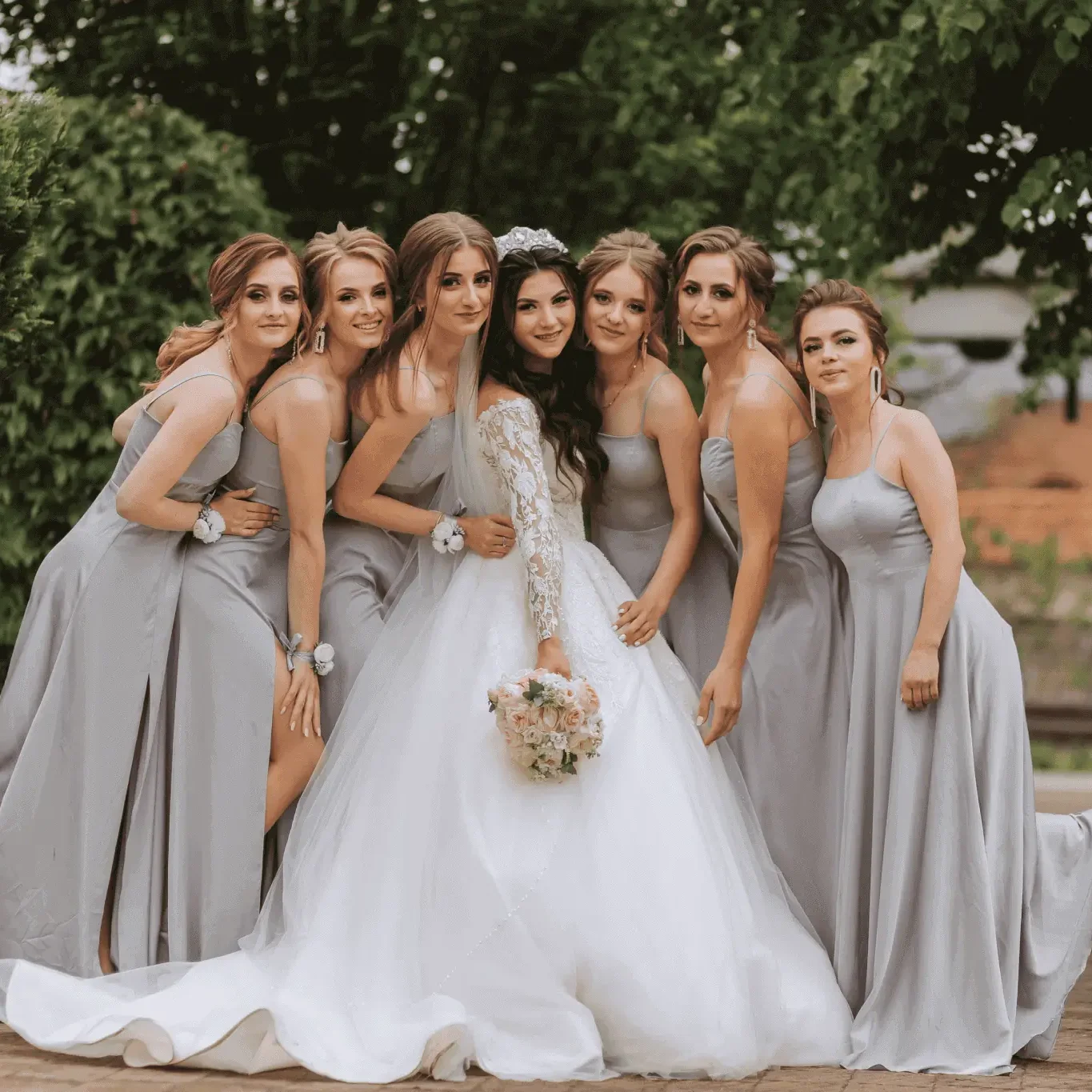 Smiling bridal party wearing gray formal gowns and posing together